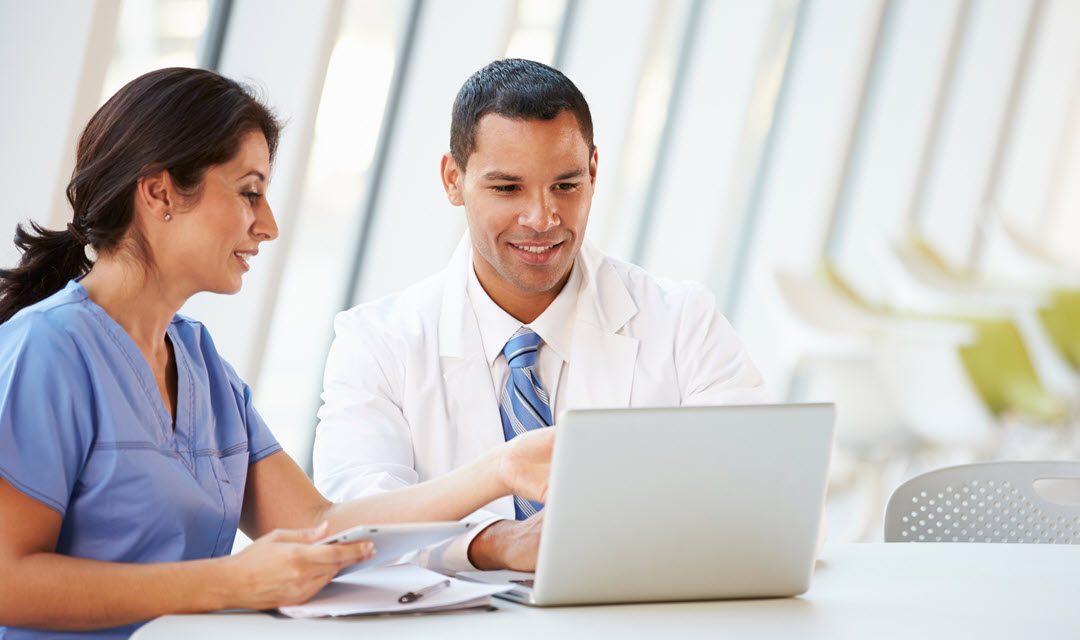 Male and female providers at a laptop