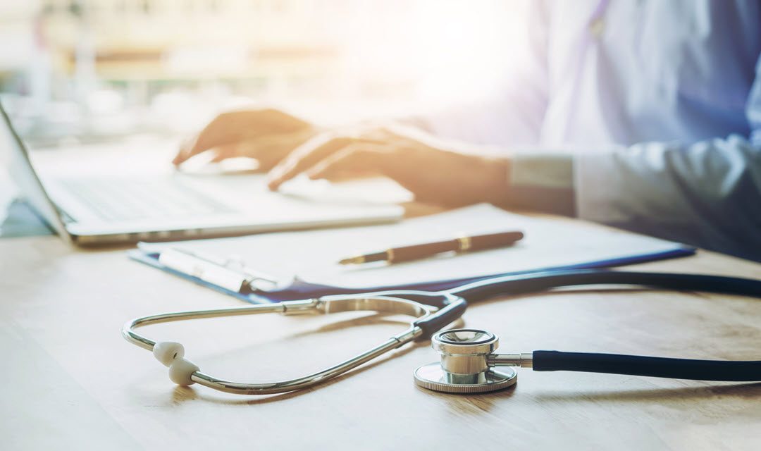 Provider typing on laptop